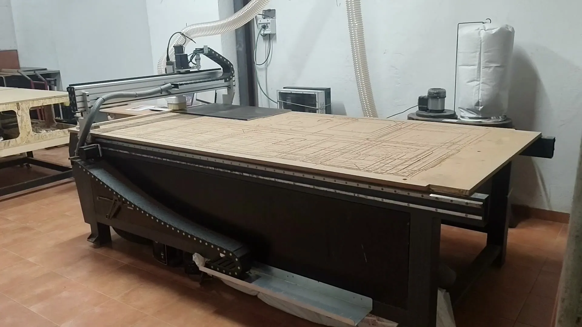 Fresadora CNC del taller de Alhóndiga Camper cortando un panel de contrachapado siguiendo el plano de una furgoneta